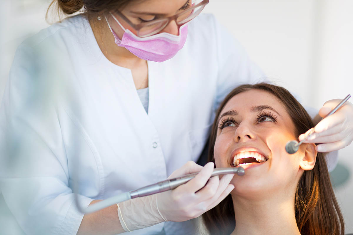a woman sees her general dentist to prevent tooth decay
