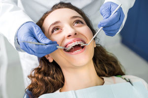 teenage girl having dental braces in tx adjusted during orthodontic services in tx