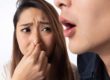 a girl plugs her nose because someone has bad breath