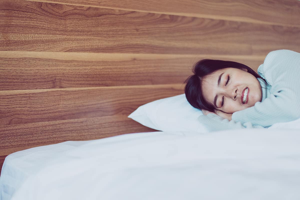 teeth grinding woman having trouble sleeping from teeth grinding