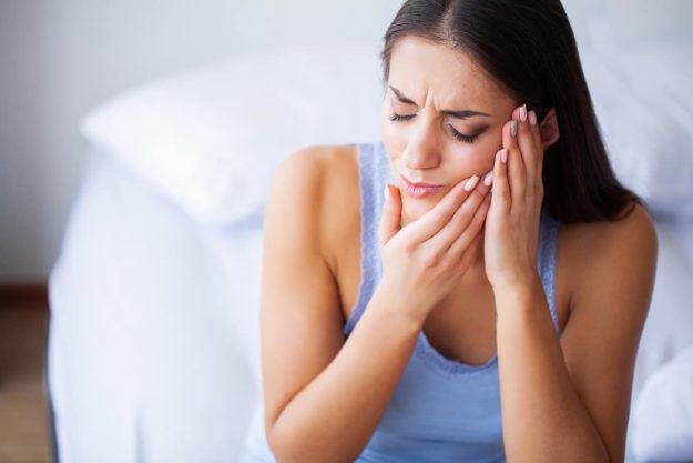 tooth cavity woman holding her jaw from tooth cavity pain